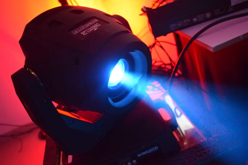 Cabeza móvil de iluminación proyectando un haz azul